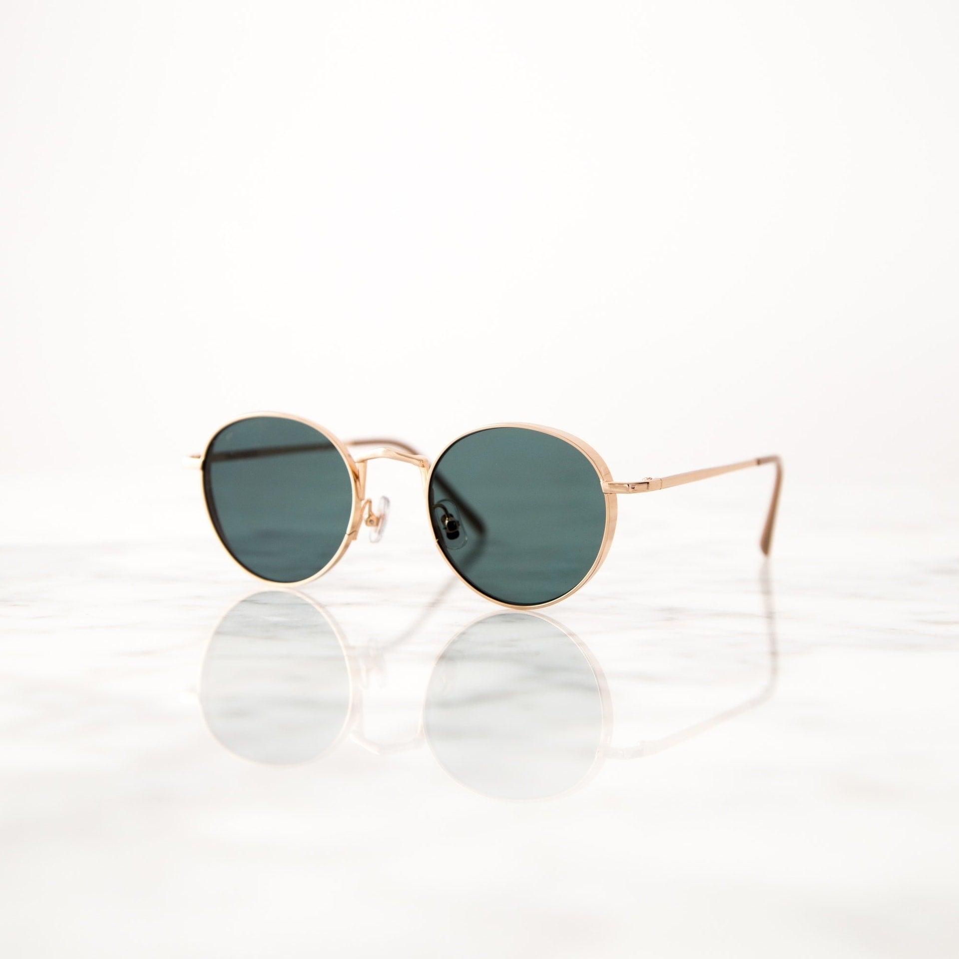 Sunglasses Gold frame sunglasses on reflective marble surface