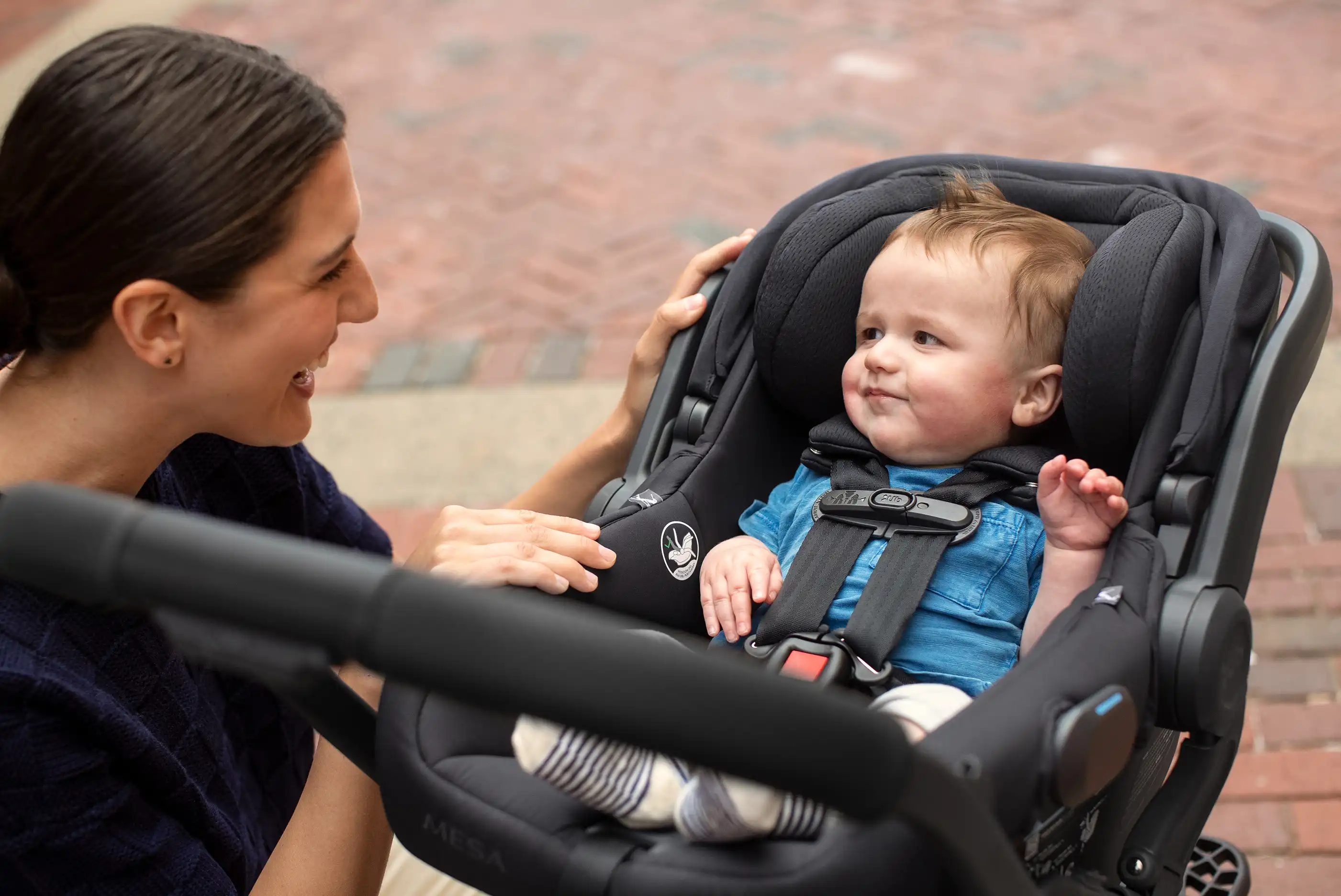 Child securely fastened in car seat with infant insert