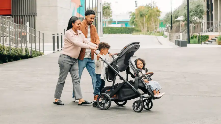 Family with three children in the Toddler Seat, RumbleSeat V3, and PiggyBack