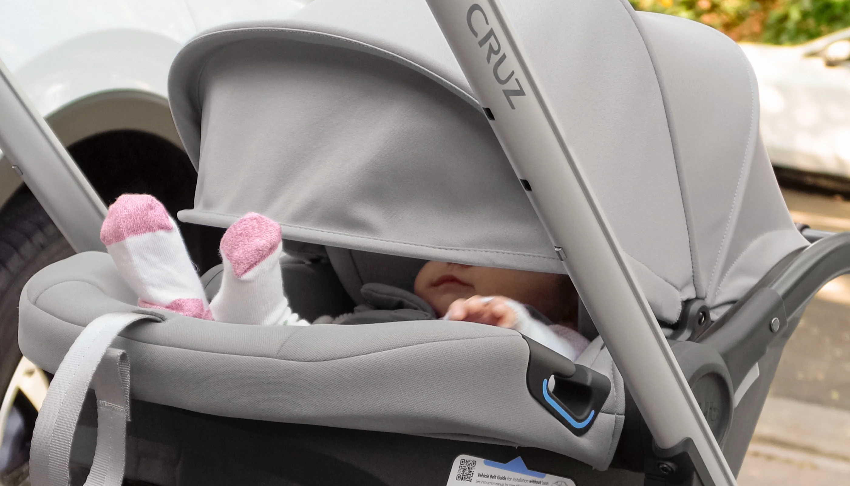 Child comfortably secured in car seat with shade extended