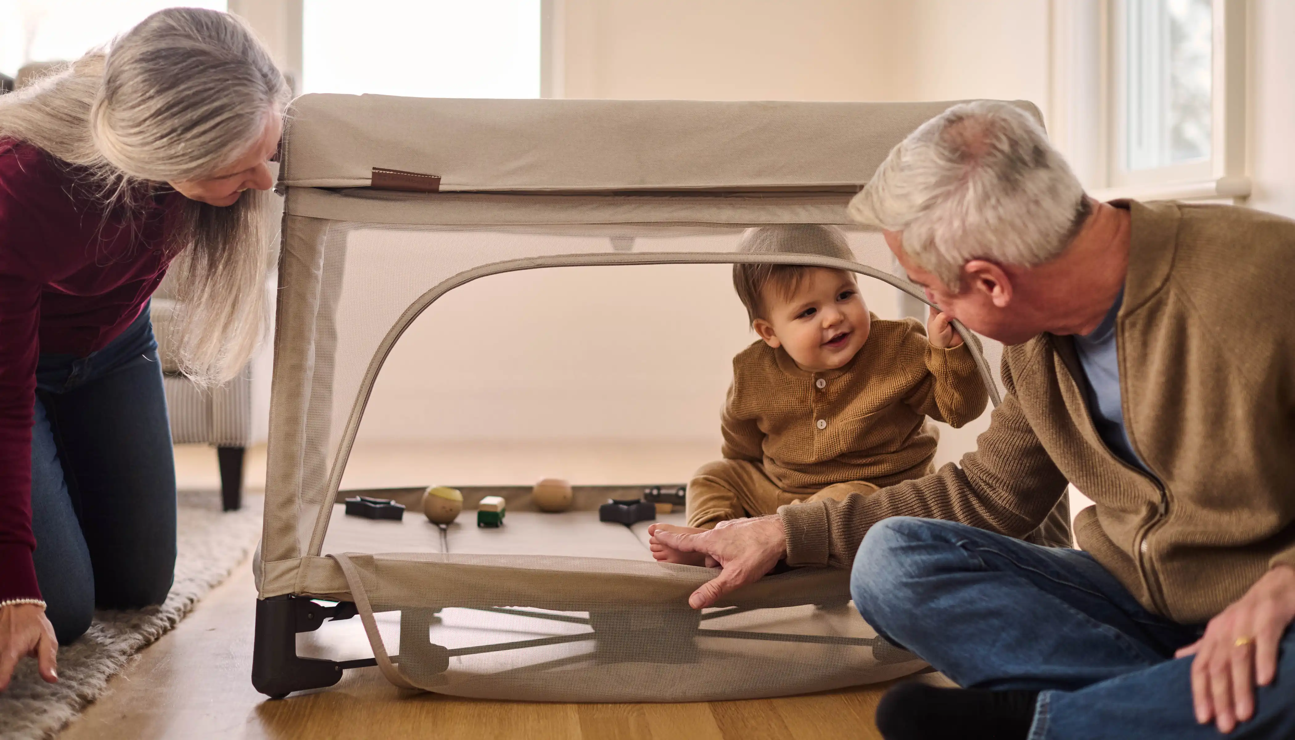 Grandparents playing with child through front opening