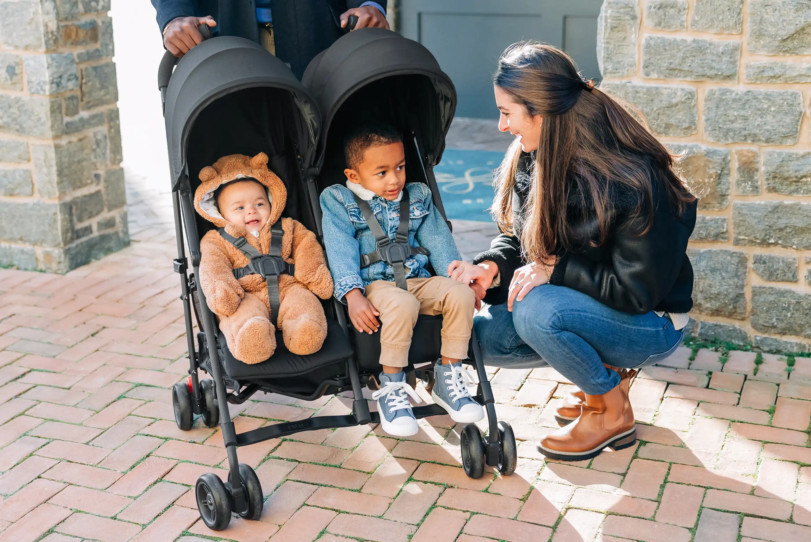 Parent with an older child and a young child, both secured in their seats