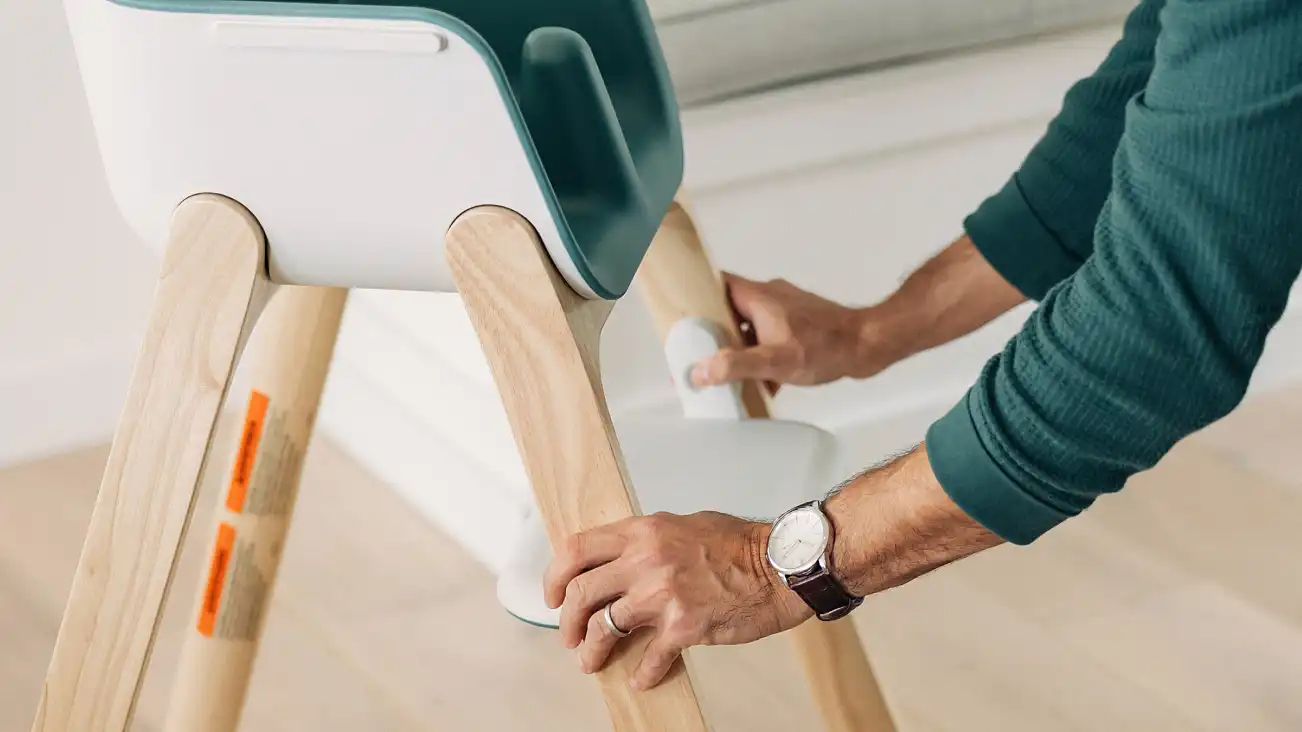 A parent adjusts the footrest to a different height