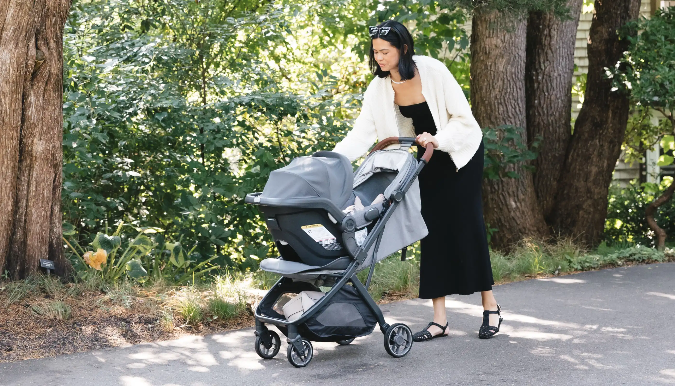 Parent with child in car seat on stroller with extended canopy